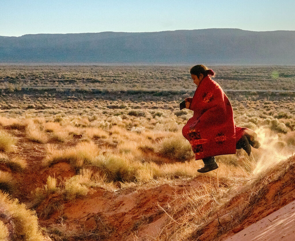 Navajo child running through the desert